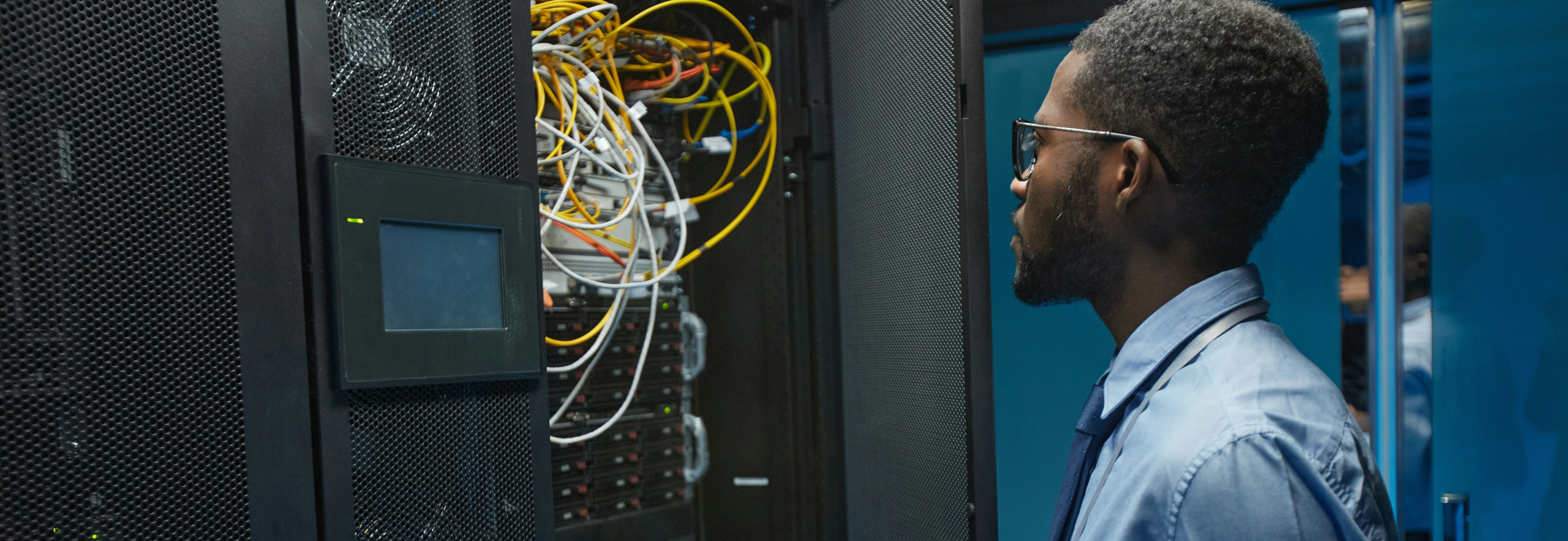 Man looking at IT switch rack